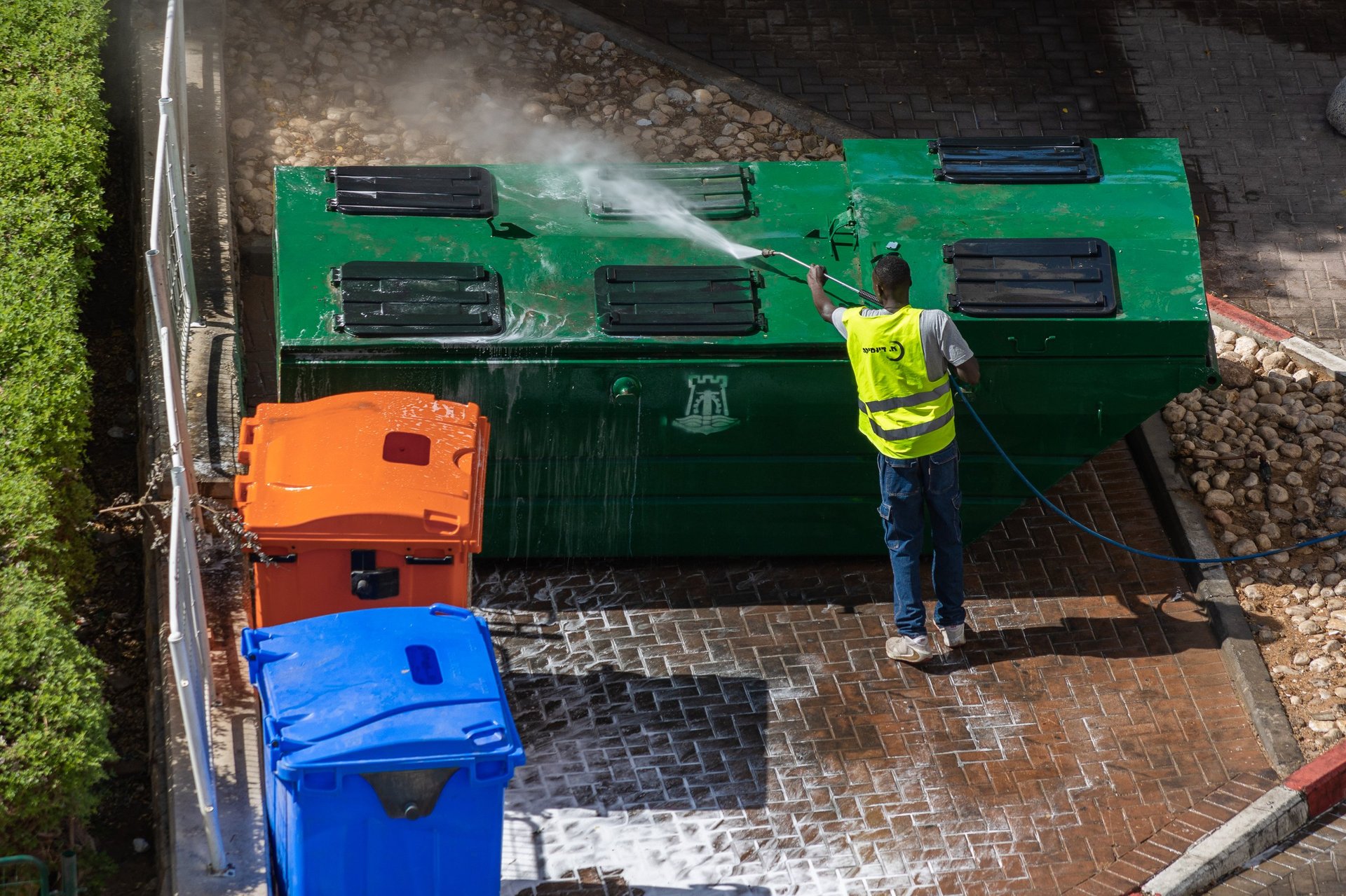 Municipal worker cleaning bins